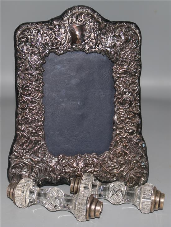 A modern silver photograph frame and a pair of silver and cut glass knife rests.